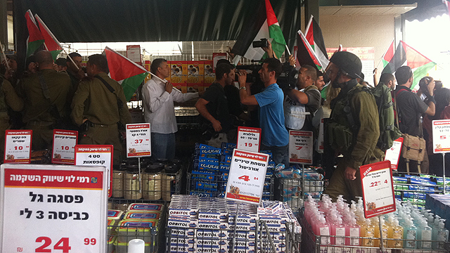 Palestinian activists protesting at Rami Levy supermarket store against settlement products (Photo: Eyal Reuven)