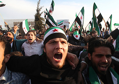 מפגינים עם דגלי סוריה המהפכנית ביום הקורבן (צילום: רויטרס) (צילום: רויטרס)