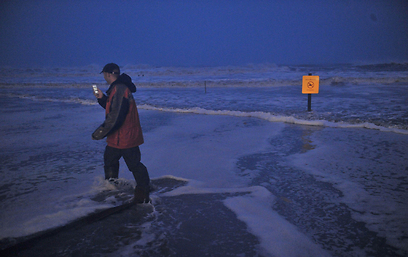 מהמר על גורלו. תושב אטלנטיק סיטי לחוף הים הסוער (צילום: AFP) (צילום: AFP)
