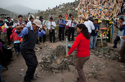 בני משפחה רוקדים ליד קבר יקירם בלימה, פרו (צילום: AP) (צילום: AP)