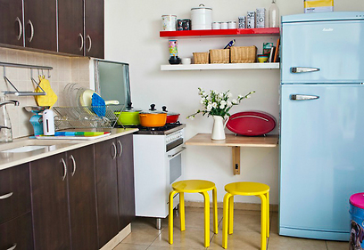 המטבח אובזר עם מקרר בצבע תכלת, מדפים בלבן ואדום ושרפרפים צהובים (צילום: זיו שדה) (צילום: זיו שדה)