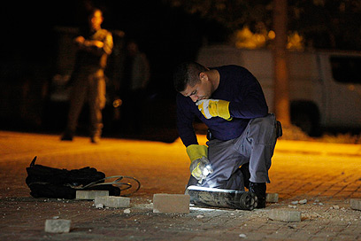 שוטר בודק נפילה ביישוב בעוטף עזה, הערב (צילום: רויטרס) (צילום: רויטרס)
