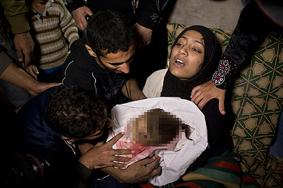תינוקת שנהרגה בתקיפה בעזה. לטענת הפלסטינים, 16 אזרחים נהרגו עד כה ברצועה (צילום: AP) (צילום: AP)