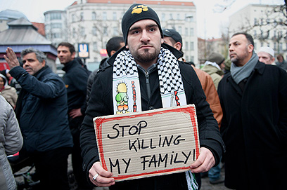 "הפסיקו להרוג את משפחתי". מפגין בברלין  (צילום: EPA) (צילום: EPA)