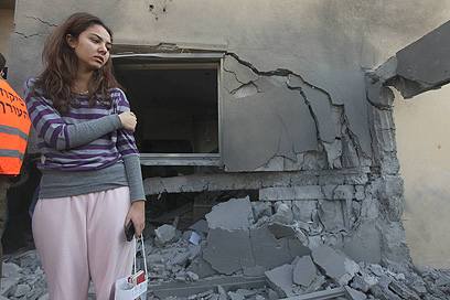 Hachmon's daughter outside ruined home (Photo: Gil Yochanan)