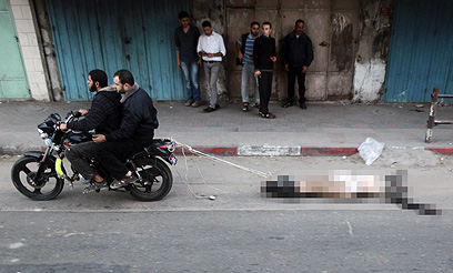 גופת אחד מ"משתפי הפעולה" נגררת ברחוב (צילום: רויטרס) (צילום: רויטרס)