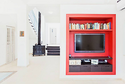 ארון מדיה וספרים בצבע אדום מוקם בתוך המחיצה הבנויה (צילום: שרון קנה) (צילום: שרון קנה)