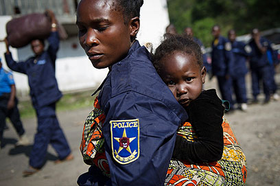שוטרת ובתה בעיר גומה שבמזרח קונגו לאחר עזיבת המורדים (צילום: AFP) (צילום: AFP)