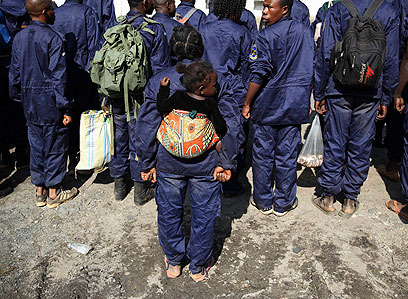 שוטרת בכוח שנכנס לגומה נושאת על גבה את ילדתה (צילום: רויטרס) (צילום: רויטרס)