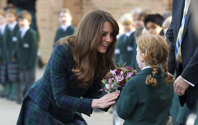 קייט מקבלת פרחים מתלמידה בבית הספר שבו התחנכה (צילום: MCT) (צילום: MCT)