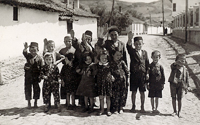 בתמונה זו נראים חיילים גרמנים כופים על ילדים יהודים להצדיע להם במועל יד. הילדים מחייכים, אולי בלית ברירה, ונראה שאינם מבינים שהפכו לכלי משחק בידיהם של חיילים שאיבדו צלם אנוש ()