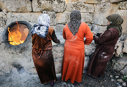 נשים אופות במערת אל-נומן. נשים שלעולם לא יצאו מהבית מסתכנות בין המחסומים כדי להביא מצרכים (צילום: AFP) (צילום: AFP)