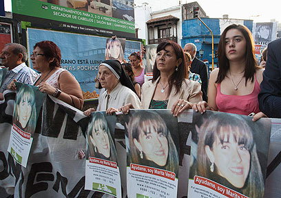 האם סוזנה מובילה הפגנה נגד הסחר בנשים, עם תמונת בתה (צילום: AP) (צילום: AP)