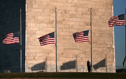 דגלי ארה"ב בחצי התורן לאחר מסע ההרג (צילום: AFP) (צילום: AFP)