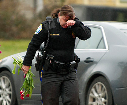 שוטרת מניחה פרחים בגלעד (צילום: AFP) (צילום: AFP)