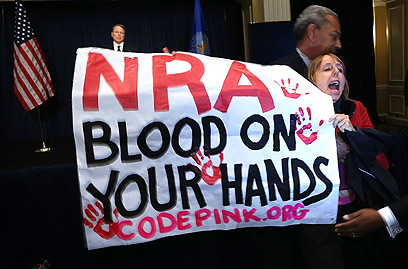"ל-NRA יש דם על הידיים". מפגינה במסיבת העיתונאים (צילום: AFP) (צילום: AFP)