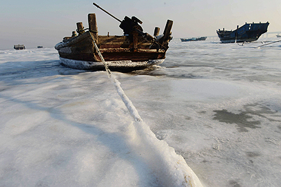 סירת דיג תקועה בקרח במחוז שנדונג (צילום: EPA) (צילום: EPA)