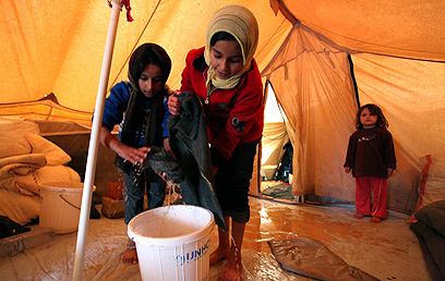 ילדים מוציאים מים מאוהל בזעתרי (צילום: AP) (צילום: AP)