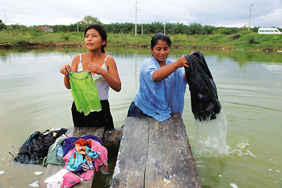 אם ובתה מכבסות בגדים במאגר מי הגשמים - מקור המים היחיד בכפר (צילום: אריה דהן, טבע הדברים) (צילום: אריה דהן, טבע הדברים)