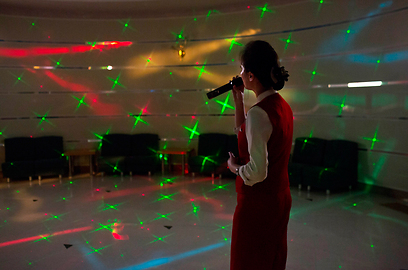 שירה בציבור. זמרת קריוקי בבית מלון בפיונגיאנג (צילום: AP) (צילום: AP)