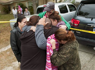 בני משפחה ושכנים מנחמים את ג'רמי בוש שאיבד את אחיו (צילום: AP) (צילום: AP)