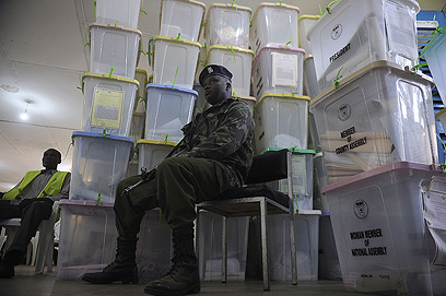 יושב על המשמר. אבטחה סביב פתקי הצבעה בעיר קקמגה (צילום: AFP) (צילום: AFP)