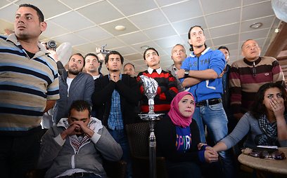 אזרחים בפורט סעיד צופים בטלוויזיה בהקראת גזרי הדין (צילום: AFP) (צילום: AFP)