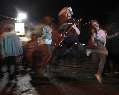 המוזיקאי מייק רוקט בהופעת רחוב ובאוויר (צילם: EPA) (צילם: EPA)