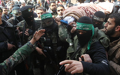 לוחמי חמאס נושאים את גופתה של פרחאת (צילום: AFP) (צילום: AFP)