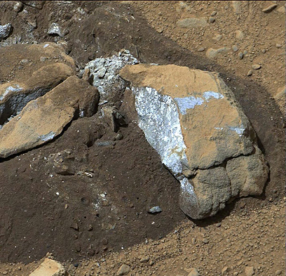 סלע שצילמה קיוריוסיטי. איזון הצבעים מעלה כי צבעו הפנימי אפרפר עד כחלחל, ולא אדמדם כמו פני השטח (צילום: EPA) (צילום: EPA)
