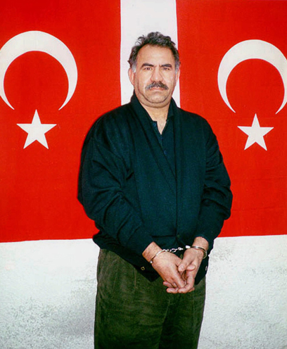 השפלה כורדית. אוצ'לאן אזוק ב-1999 וברקע דגל טורקיה (צילום: AP) (צילום: AP)