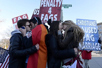 מפגינים בפטיסטים קוראים למוות להומואים, מולם מתנשקים זוגות חד-מיניים (צילום: EPA) (צילום: EPA)