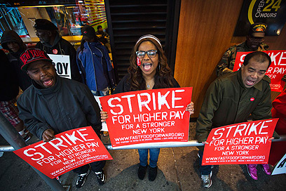 עובדים מפגינים ליד טיימס סקוור (צילום: רויטרס) (צילום: רויטרס)
