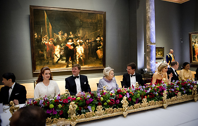 שמח בשולחן מול ציורו המפורסם של רמברנדט "משמר הלילה". רייקסמוזיאום (צילום: Gettyimages) (צילום: Gettyimages)