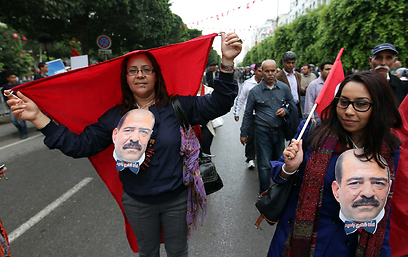 מפגינות בתוניסיה נושאות את דיוקנו של מנהיג האופוזיציה שנרצח, שוקרי בלעיד (צילום: EPA) (צילום: EPA)