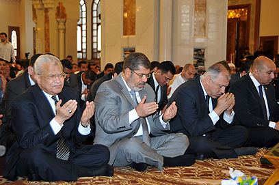 הצליח להנהיג מדינה שסועה בניגוד לכל התחזיות. מורסי מתפלל במסגד בקהיר (צילום: AP) (צילום: AP)
