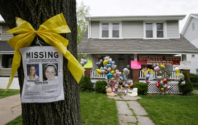 ביתה של אחת החטופות, ולצדו מודעה על היעדרה (צילום: AP) (צילום: AP)