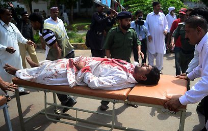 פצוע בפיצוץ בקראצ'י מובל על אלונקה (צילום: AFP) (צילום: AFP)