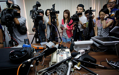"מאושרת". עיתונאים מקשיבים לקולה של וו בשיחת ועידה שערכו עמה (צילום: AP) (צילום: AP)