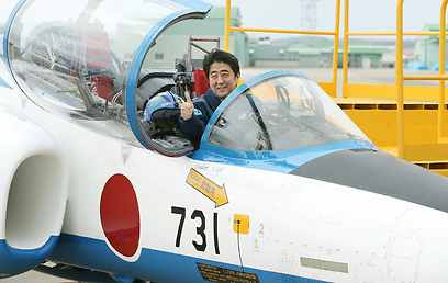 הצטלם על מטוס קרב שנשא את מספר היחידה החשאית שביצעה ניסויים באזרחים סינים. ראש הממשלה היפני אבה (צילום: AFP) (צילום: AFP)