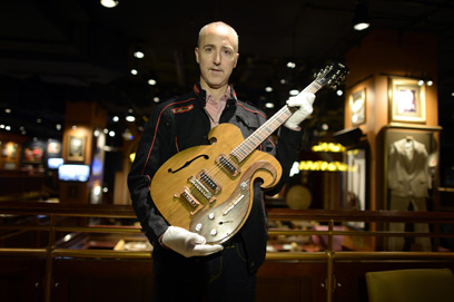 מנהל בית המכירות והגיטרה. ציפו ל-200 עד 300 אלף (צילום: AFP) (צילום: AFP)
