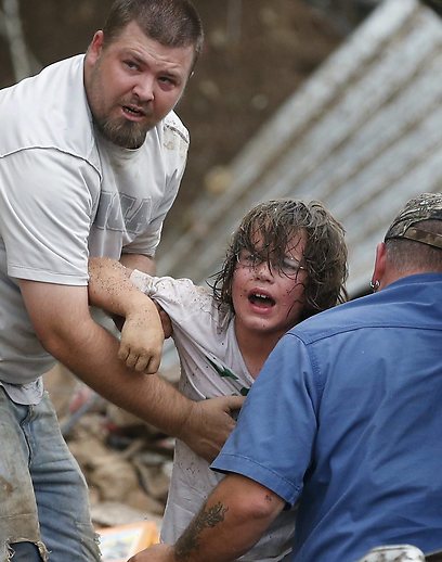 אב מחלץ את בנו מהריסות בית הספר שנפגע בסופה (צילום: AP) (צילום: AP)
