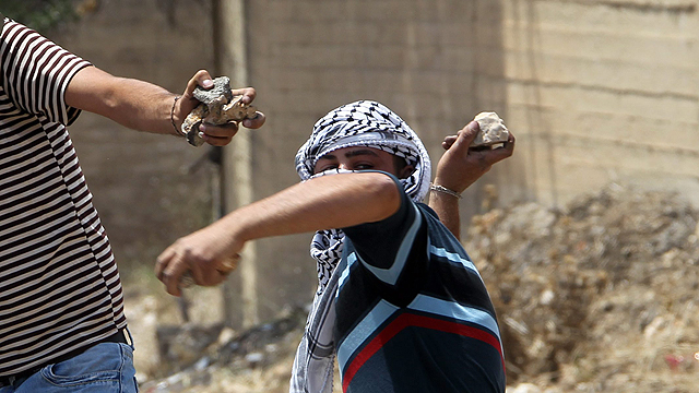 A Palestinian demonstrator about to throw a stone near Hebron. (Photo: EPA)