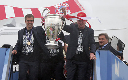 המאמן היינקס והקפטן לאם נוחתים במינכן עם הגביע אחרי 12 שנות בצורת (צילום: AP) (צילום: AP)