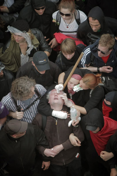 מפגינים מטפלים בעיניו של חברם, שנפגע מתרסיס פלפל (צילום: AFP) (צילום: AFP)