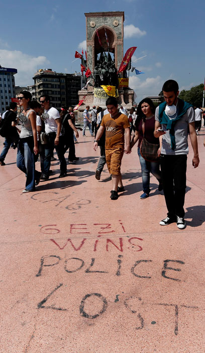 מפגינים ליד פסלו של אטאטורק. "גזי ניצח, המשטרה הפסידה" (צילום: EPA) (צילום: EPA)