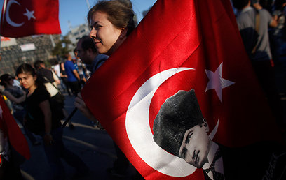 מפגינה בטקסים אוחזת בדגל עם דיוקנו של כמאל אטאטורק (צילום: AP) (צילום: AP)