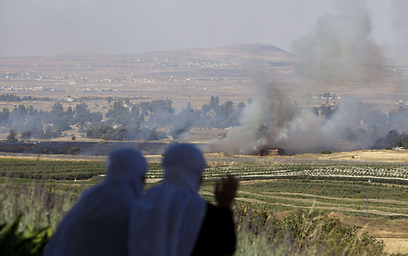 נשים דרוזיות צופות משטח ישראל על עשן שמיתמר מאזור קרבות בסוריה (צילום: AFP) (צילום: AFP)