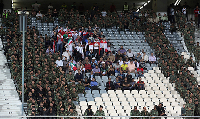 הגנה לוחצת. חיילים איראנים מאבטחים קבוצת אוהדים מלבנון שבאו לעודד את נבחרתם במשחק מול איראן בבית האסייתי של מוקדמות גביע העולם 2014. במשחק עצמו ניצחה איראן המארחת בתוצאה 0:4 (צילום: AP) (צילום: AP)