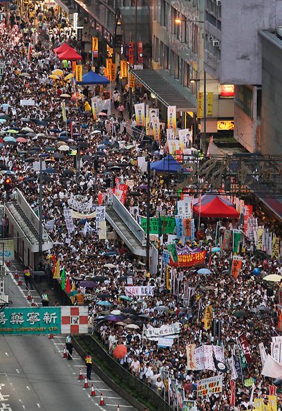 ההמונים מצטופפים עם מטריות, היום בהונג-קונג (צילום: AP) (צילום: AP)